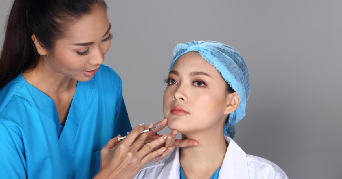 Woman undergoing Kybella treatment in San Mateo, CA to reduce chin fat, with a provider administering the injection beneath her chin.